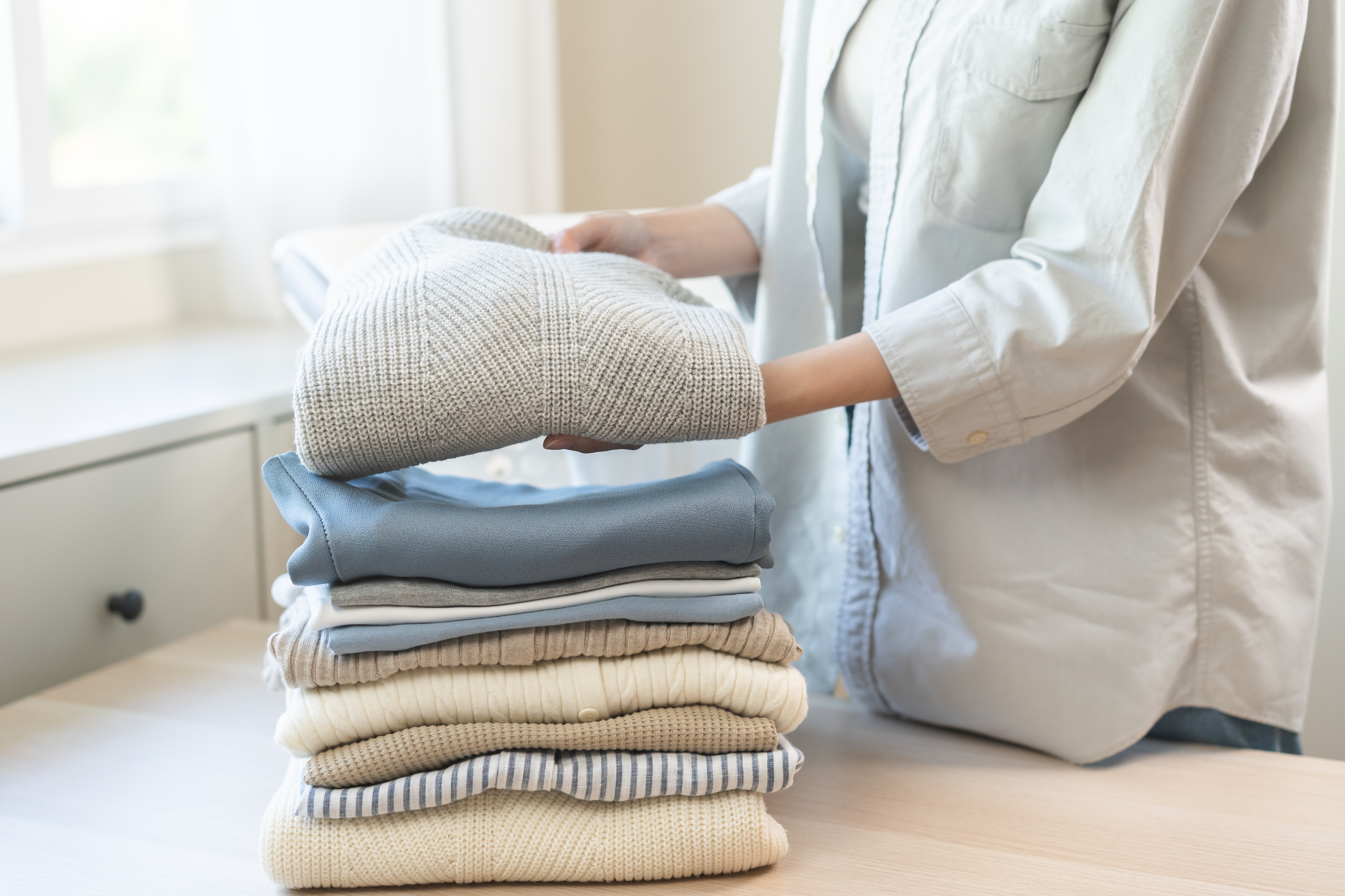 Woman Folding Stack Of Laundry